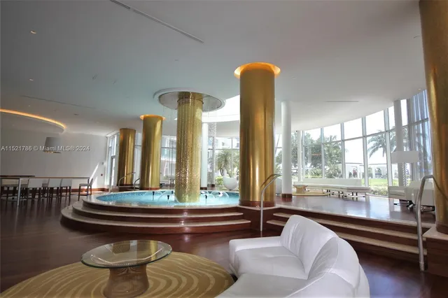 a living room with furniture and floor to ceiling windows