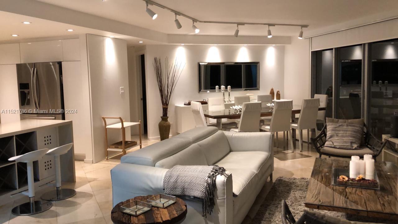 5151 Collins Avenue, Unit 532 Miami Beach, FL 33140 - Photo 5 of 62 a living room with furniture a flat screen tv and a view of kitchen