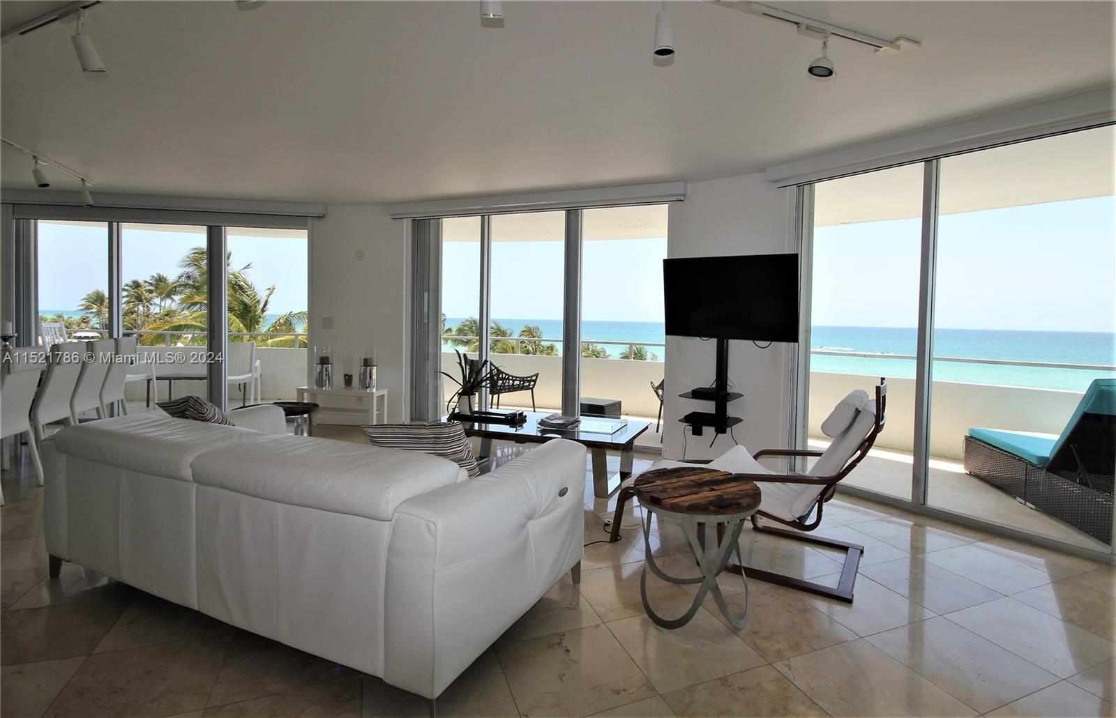 5151 Collins Avenue, Unit 532 Miami Beach, FL 33140 - Photo 57 of 62 a living room with furniture a large window and a flat screen tv