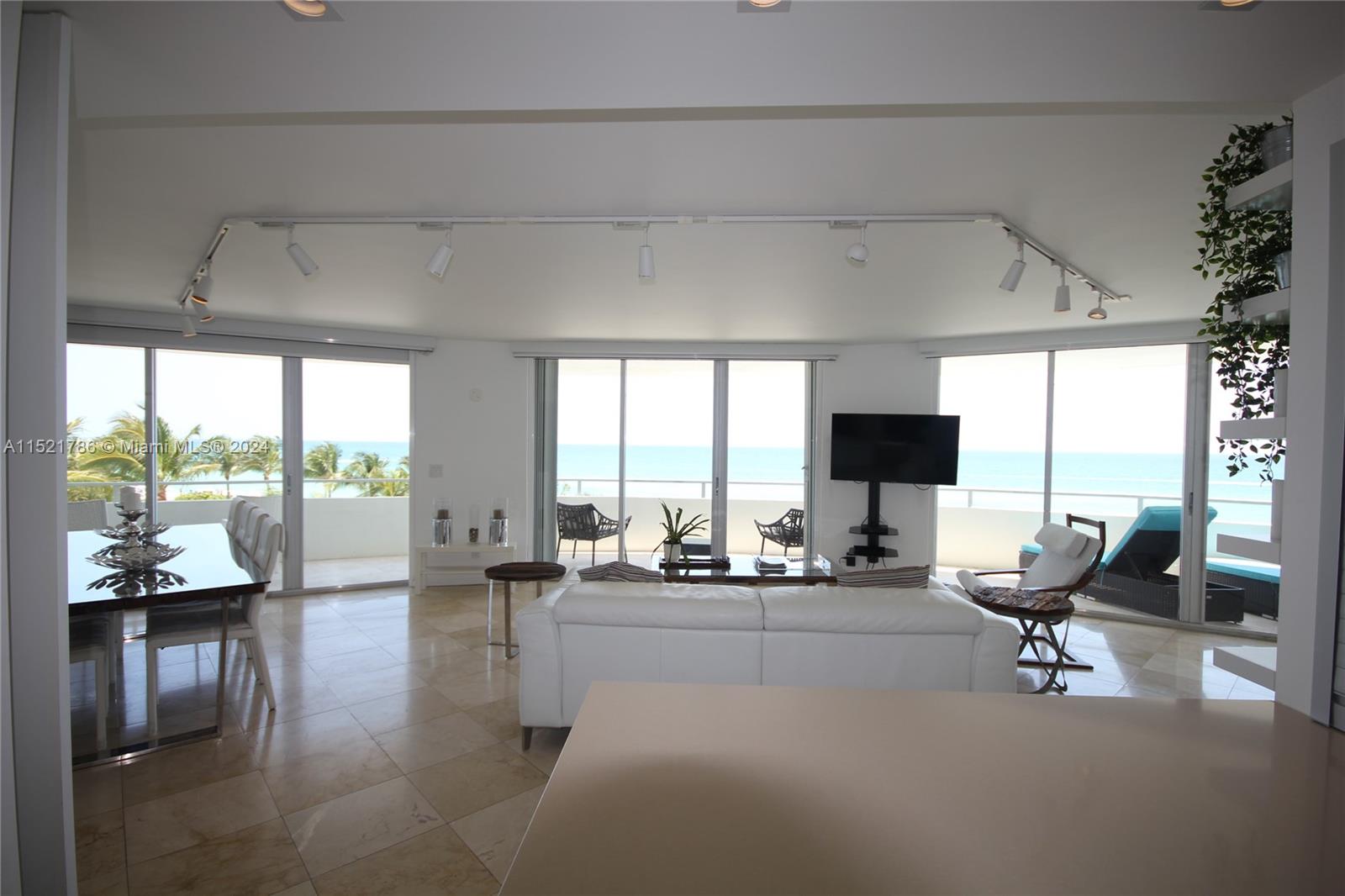 5151 Collins Avenue, Unit 532 Miami Beach, FL 33140 - Photo 62 of 62 a living room with furniture and floor to ceiling windows