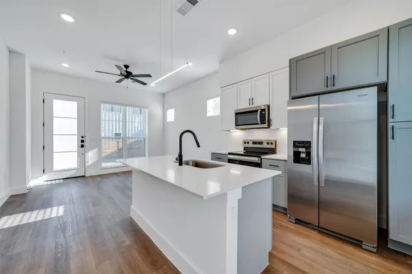 a kitchen with a refrigerator a sink and cabinets