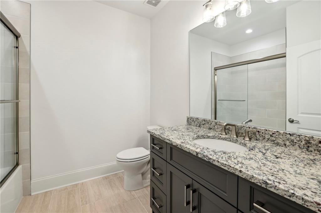 3750 Robinson Road Northeast Marietta, GA 30068 - Photo 39 of 57 a bathroom with a granite countertop sink a toilet and a mirror