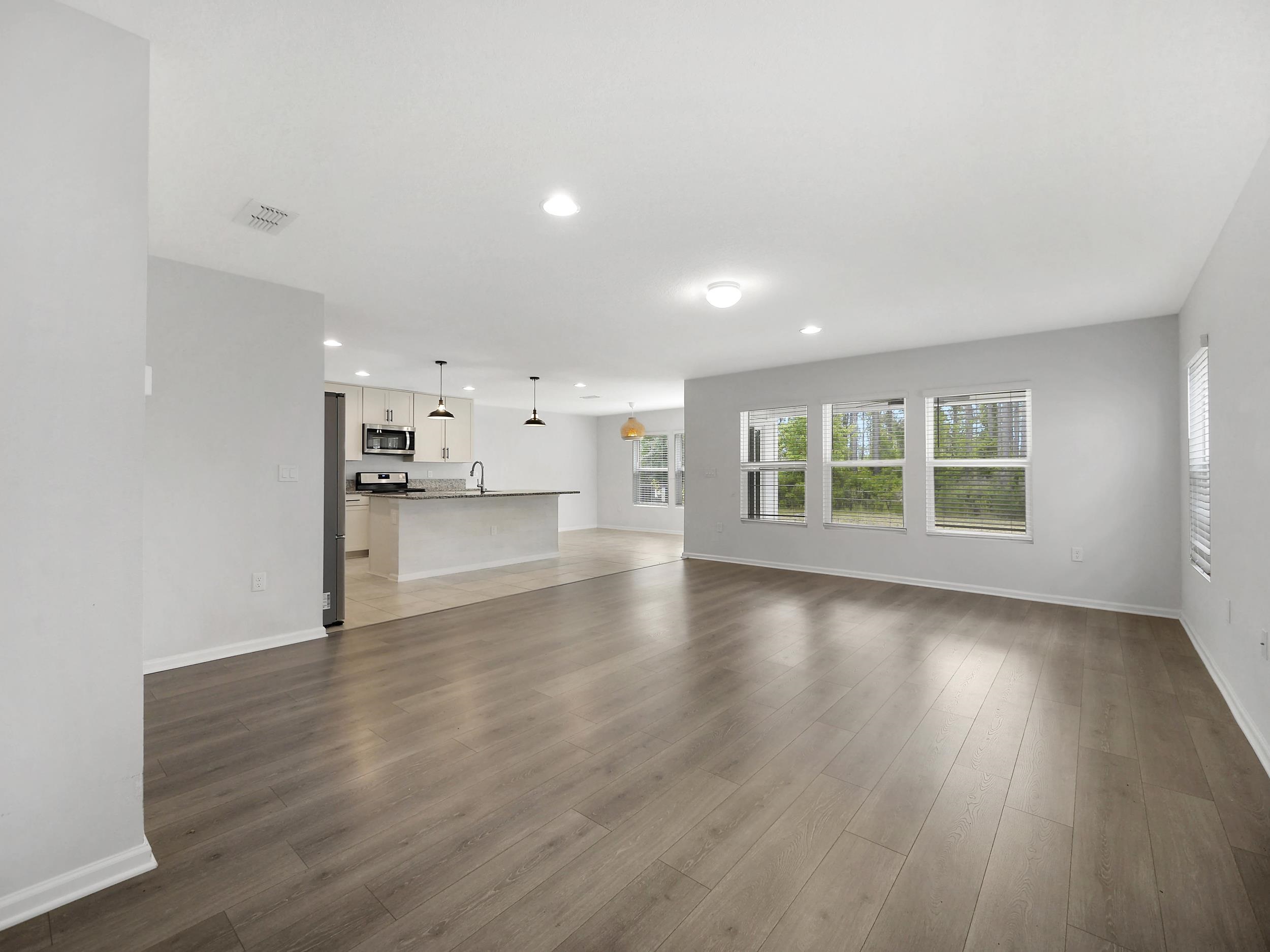597 Meadow Ridge Drive St. Augustine, FL 32092 - Photo 12 of 56 a view of an empty room with a window and wooden floor