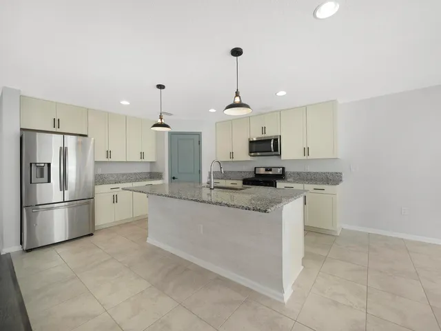 a kitchen with granite countertop a sink and a stove