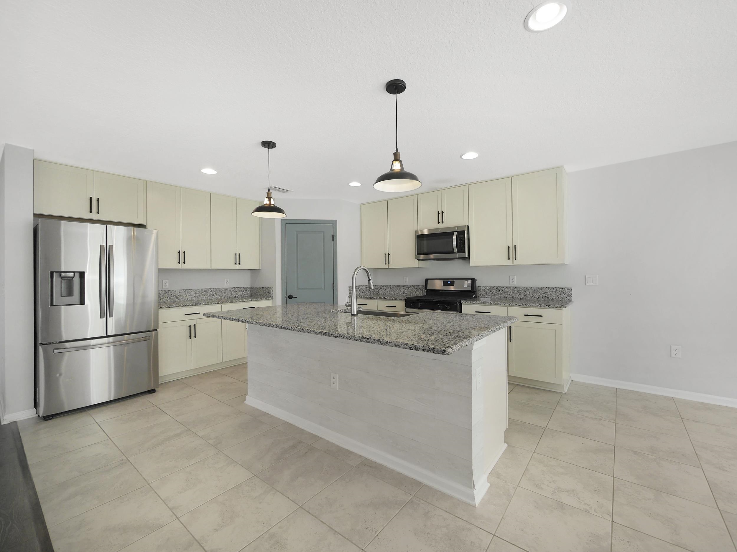 597 Meadow Ridge Drive St. Augustine, FL 32092 - Photo 15 of 56 a kitchen with stainless steel appliances granite countertop a refrigerator a sink a stove a microwave and a refrigerator