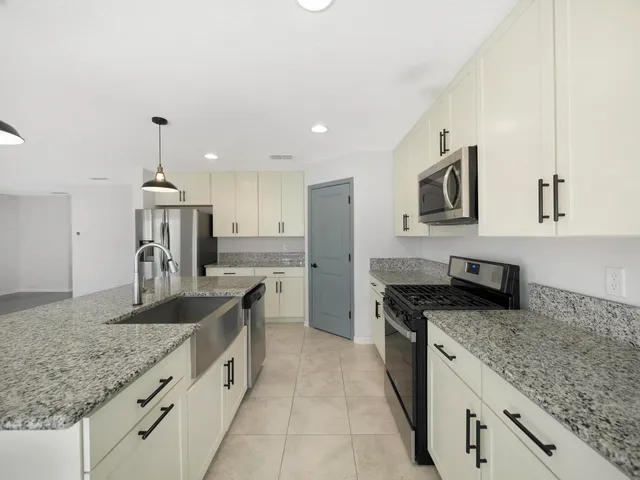 a kitchen with granite countertop a sink and stove top oven