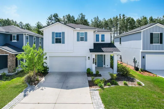 a front view of a house with a garden and plants