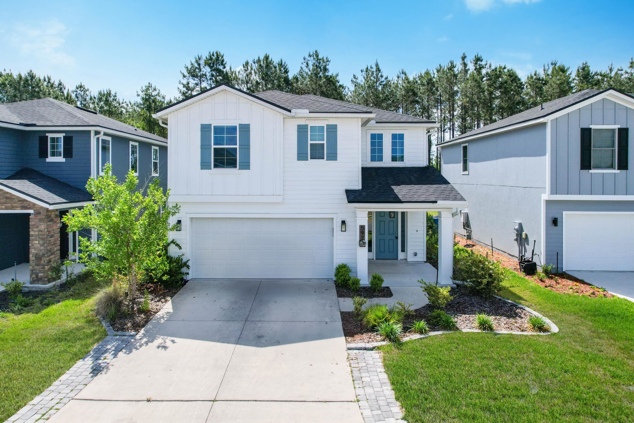 597 Meadow Ridge Drive St. Augustine, FL 32092 - Photo 2 of 56 a front view of a house with a garden and plants