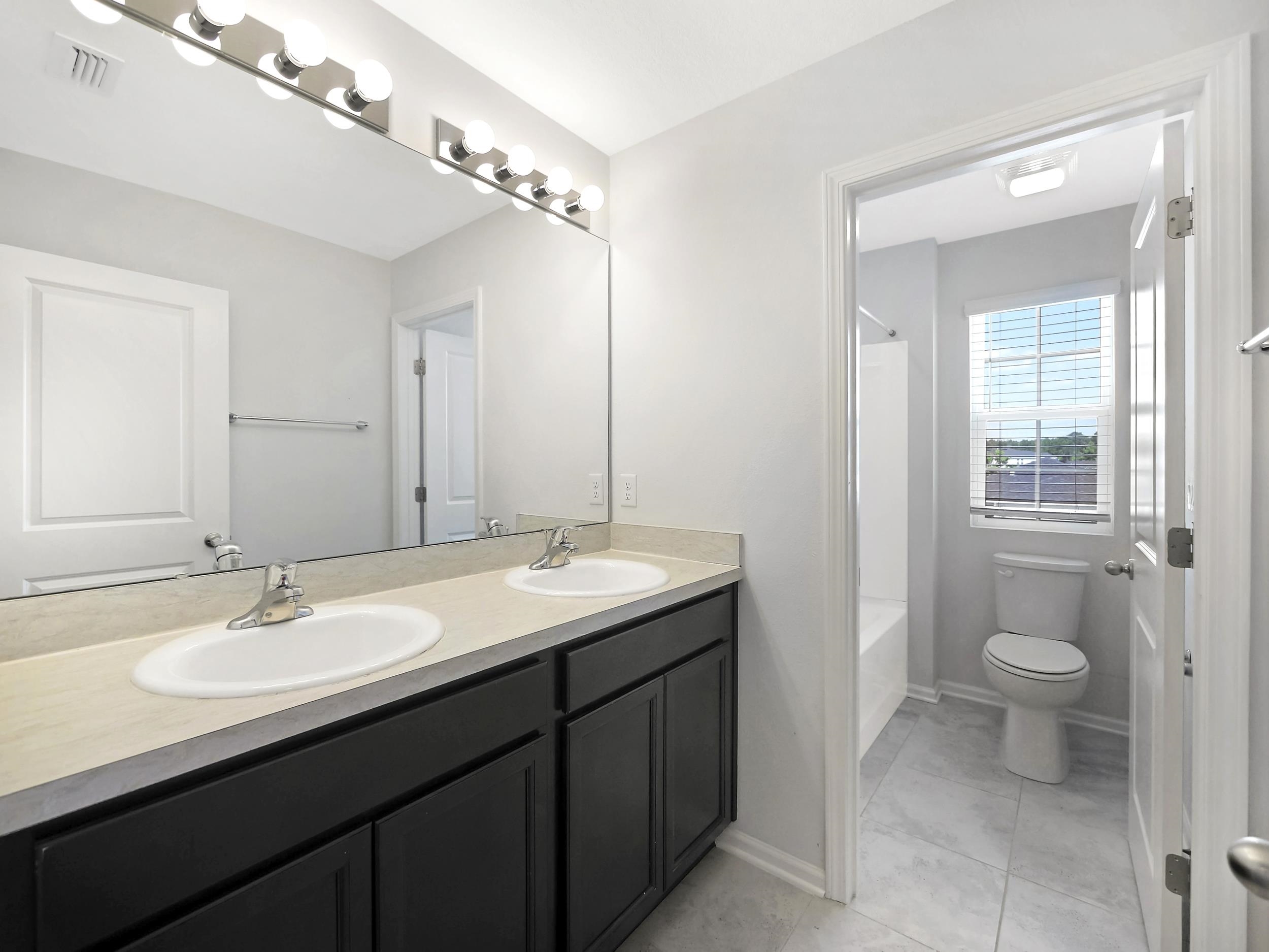 597 Meadow Ridge Drive St. Augustine, FL 32092 - Photo 26 of 56 a bathroom with a sink double vanity and a toilet