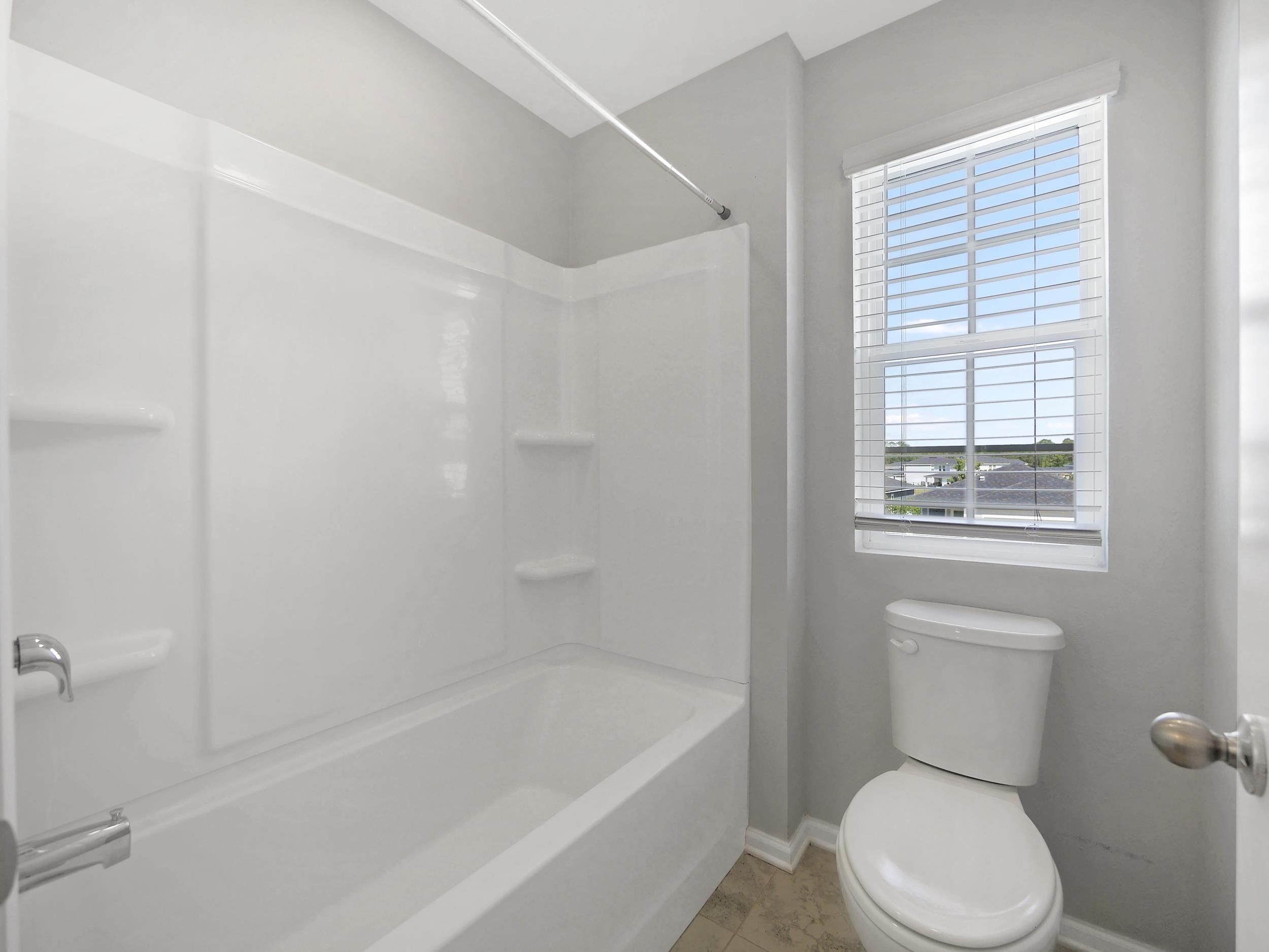 597 Meadow Ridge Drive St. Augustine, FL 32092 - Photo 27 of 56 a white toilet sitting next to a bath tub