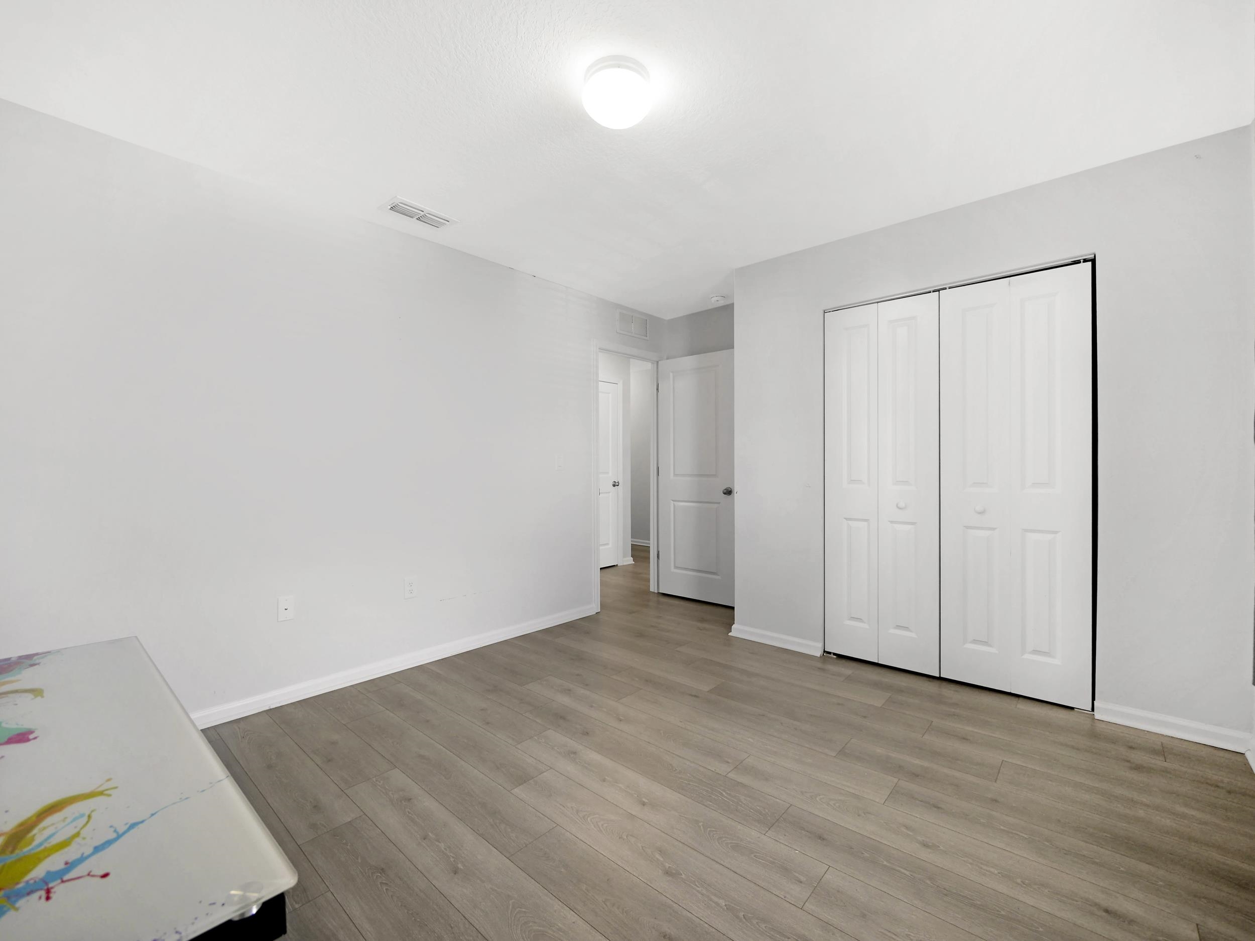 597 Meadow Ridge Drive St. Augustine, FL 32092 - Photo 28 of 56 an empty room with wooden floor and closet