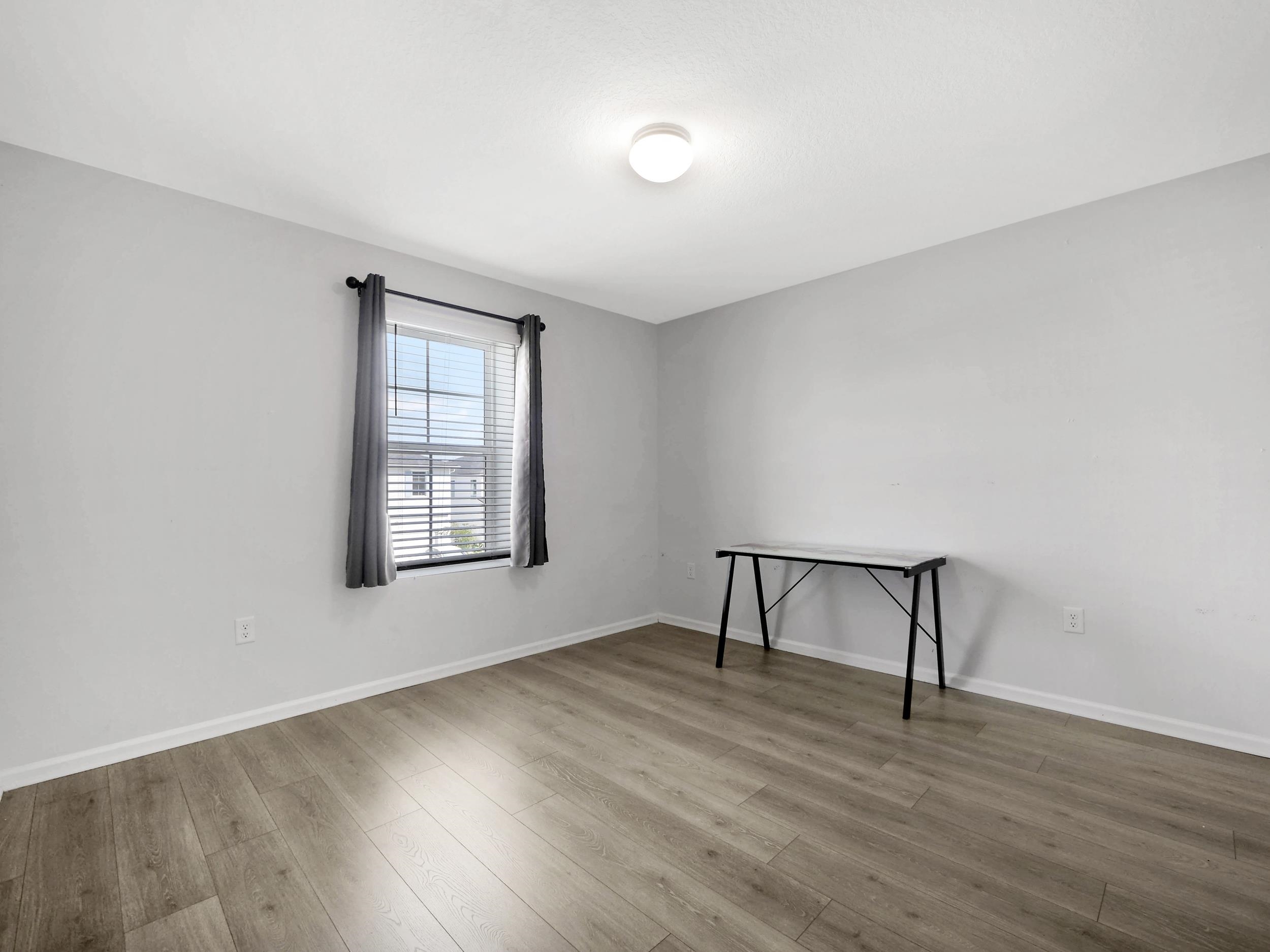 597 Meadow Ridge Drive St. Augustine, FL 32092 - Photo 29 of 56 a view of an empty room with wooden floor and a window