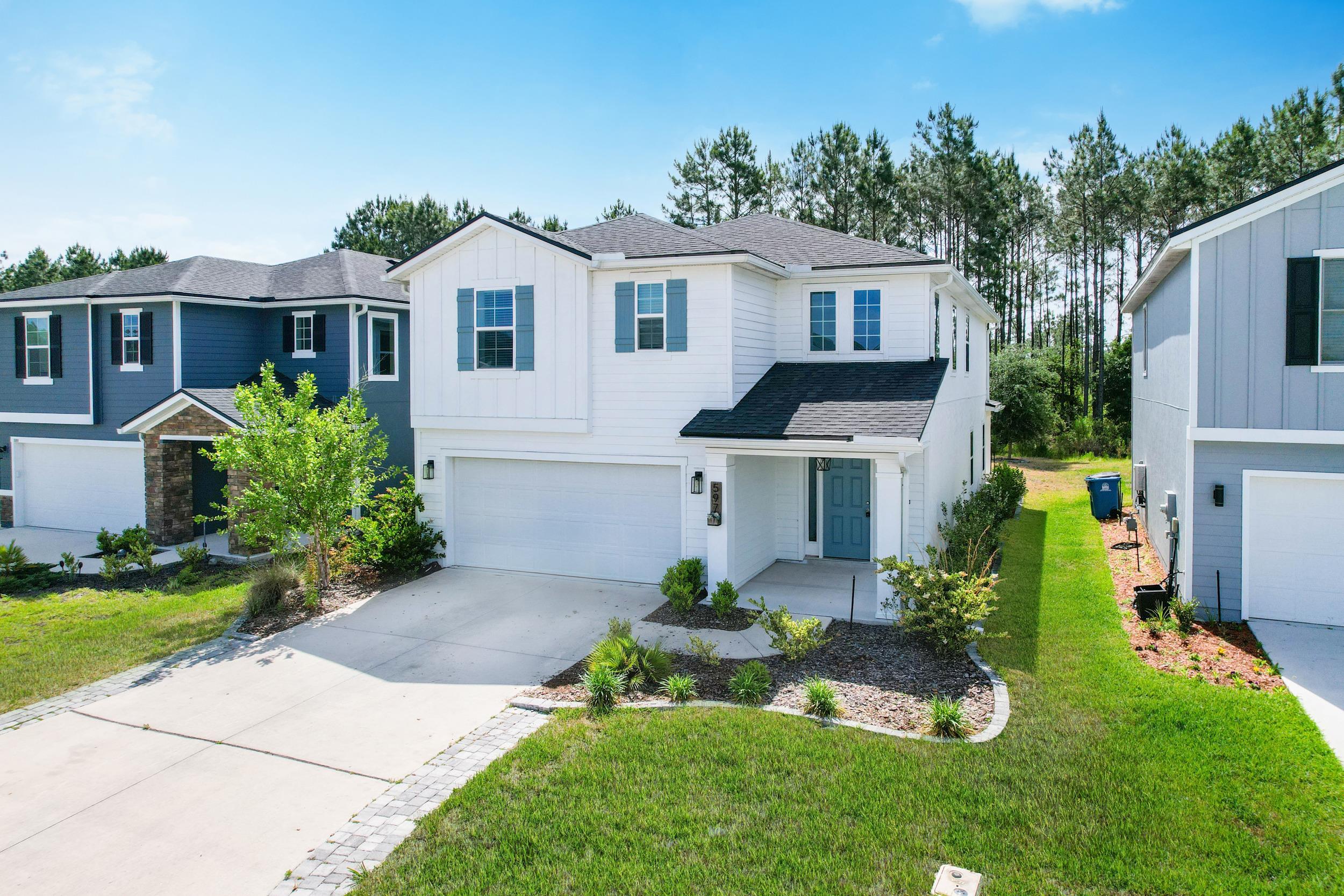 597 Meadow Ridge Drive St. Augustine, FL 32092 - Photo 3 of 56 a front view of a house with a garden and plants