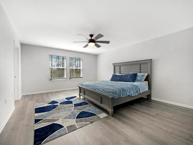 a bedroom with a bed and a ceiling fan