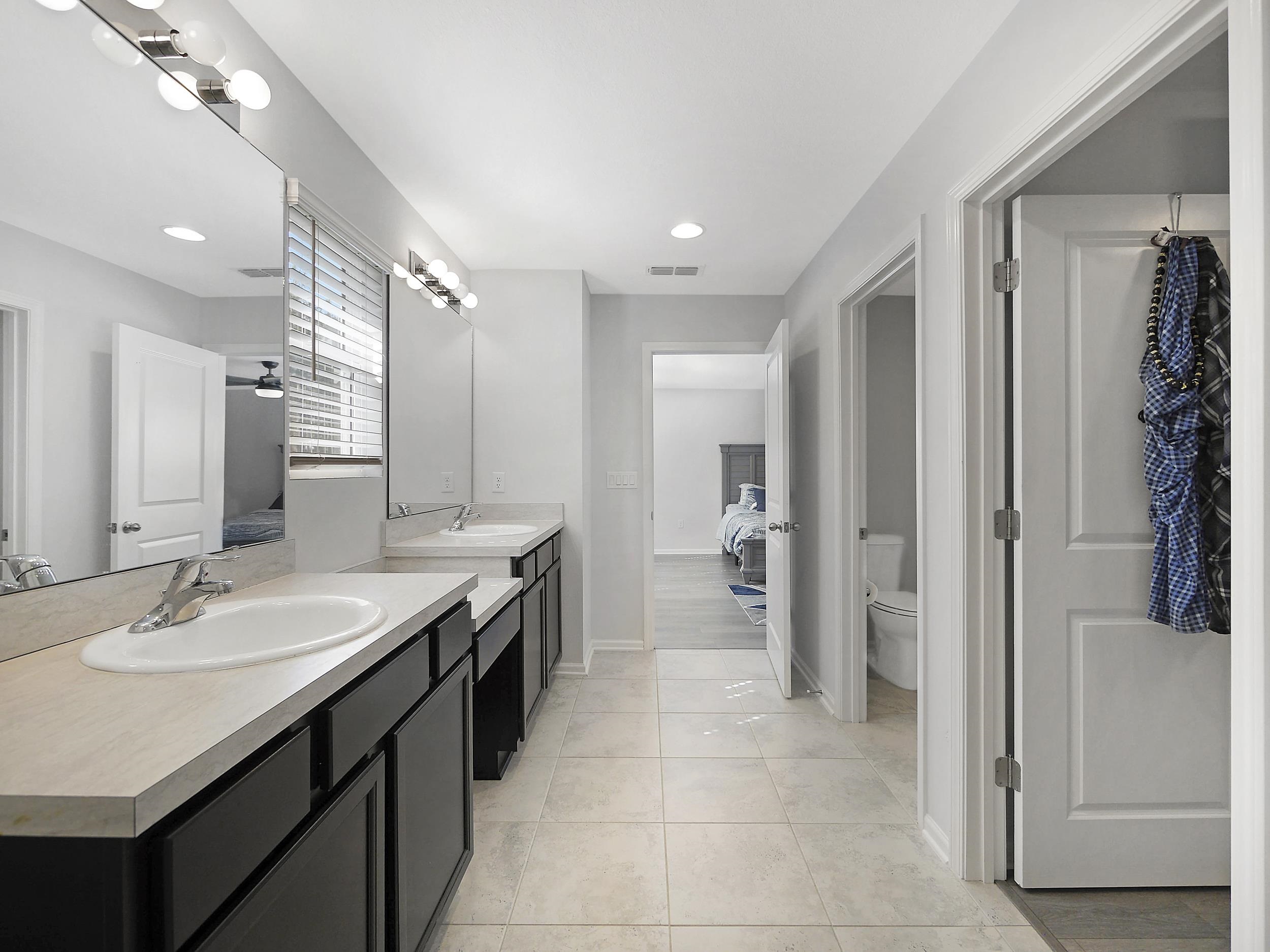 597 Meadow Ridge Drive St. Augustine, FL 32092 - Photo 41 of 56 a spacious bathroom with a double vanity sink a mirror and a shower