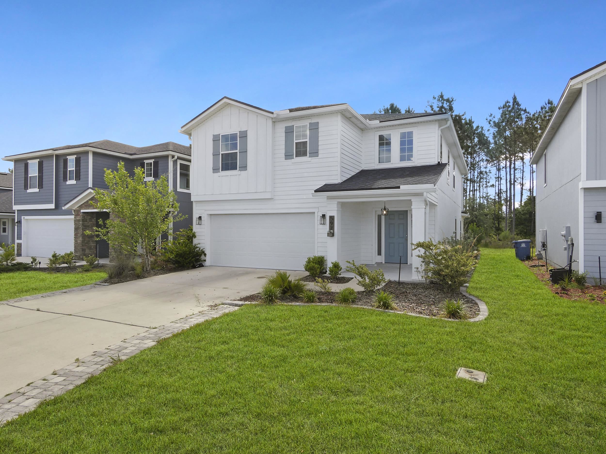 597 Meadow Ridge Drive St. Augustine, FL 32092 - Photo 48 of 56 a front view of a house with garden and porch