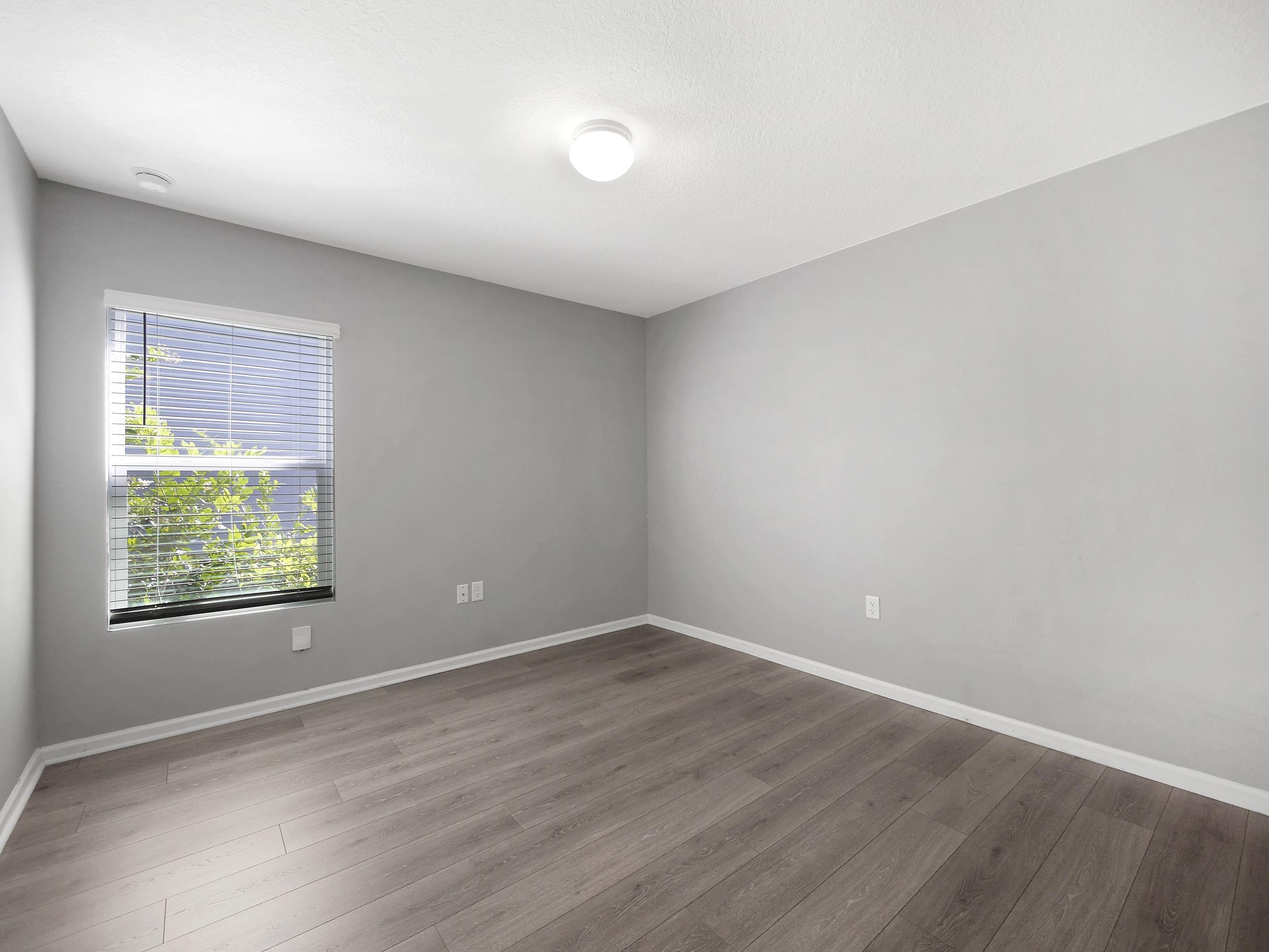 597 Meadow Ridge Drive St. Augustine, FL 32092 - Photo 8 of 56 an empty room with wooden floor and windows
