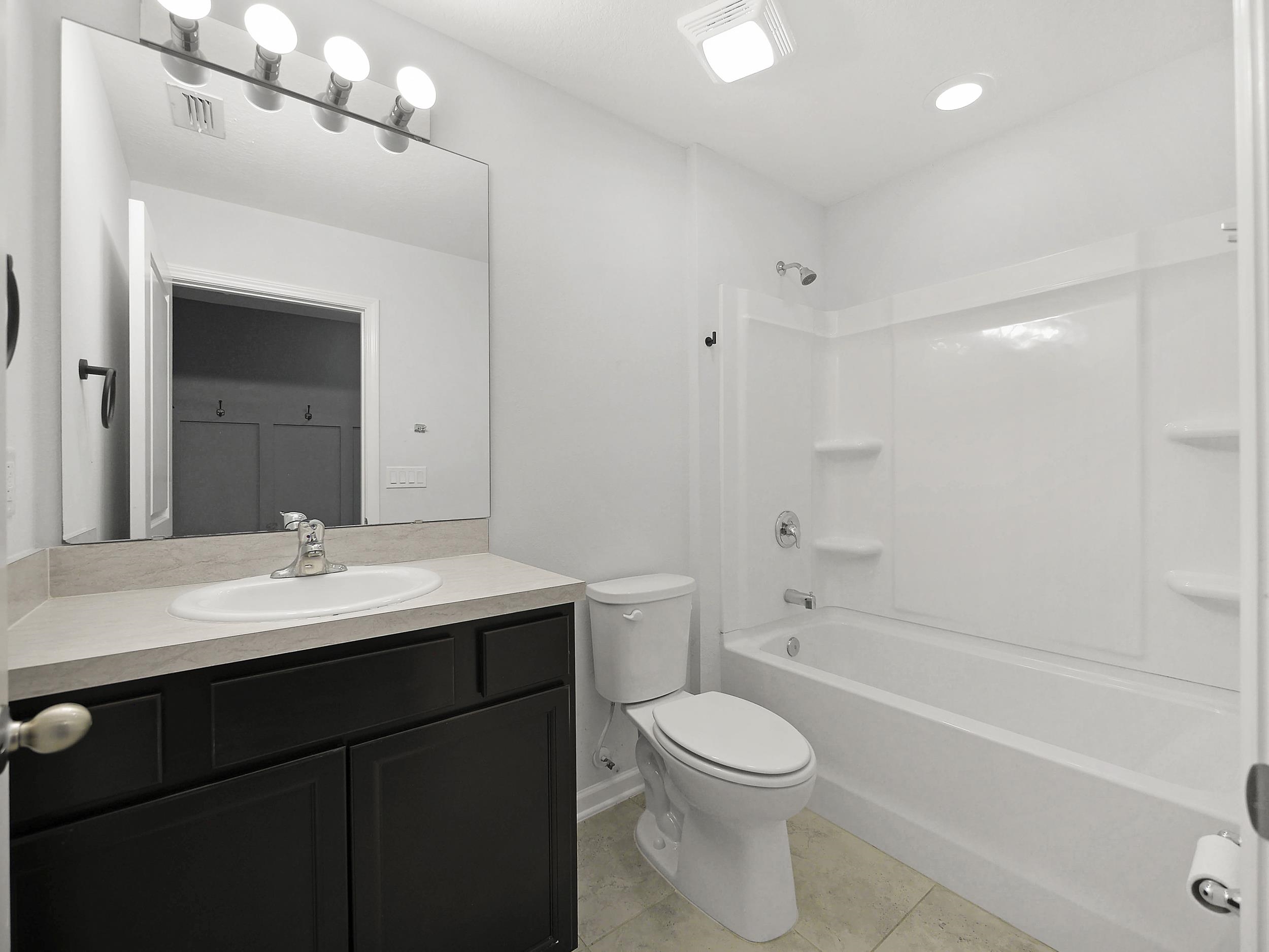 597 Meadow Ridge Drive St. Augustine, FL 32092 - Photo 10 of 56 a bathroom with a sink a toilet and shower