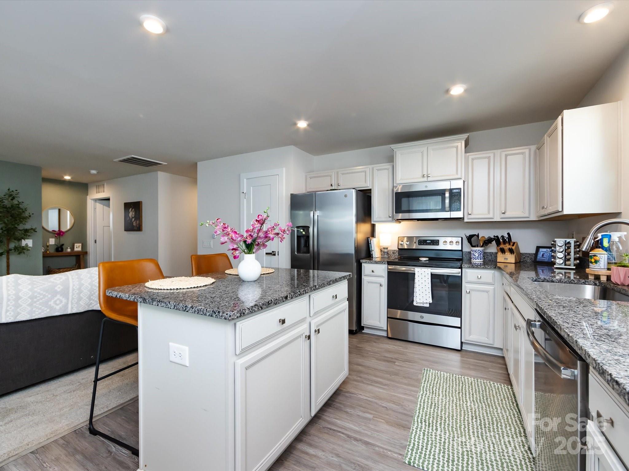 4231 Mackinnon Drive Charlotte, NC 28214 - Photo 14 of 35 a kitchen with granite countertop kitchen island cabinets and stainless steel appliances