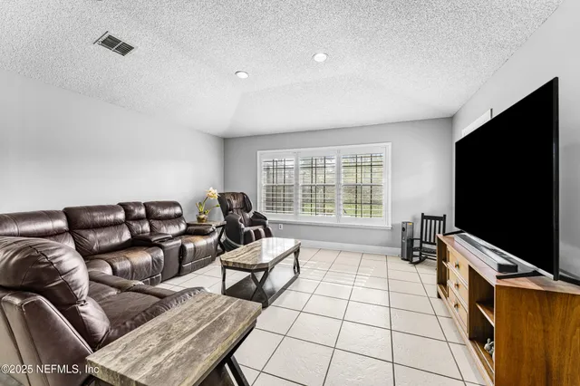 a kitchen with stainless steel appliances a stove a sink a microwave a refrigerator a stove and white cabinets