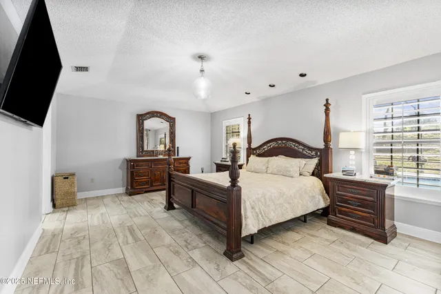 a bedroom with a bed and a chandelier