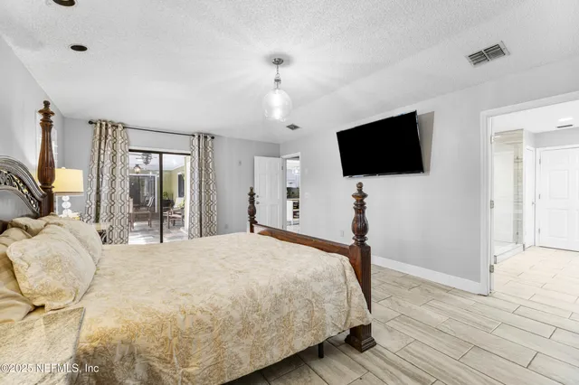 a bedroom with a bed and flat screen tv