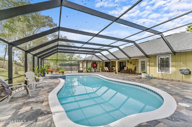 an aerial view of residential house with outdoor space and trees all around