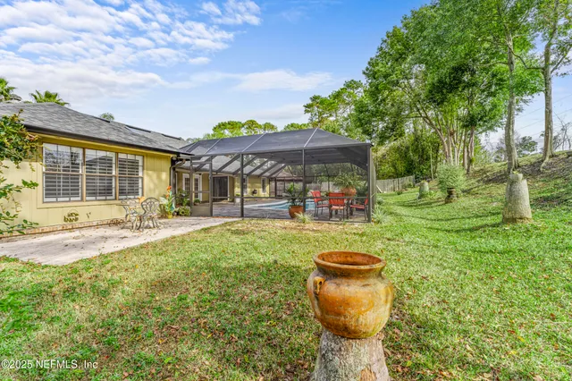 a view of a yard with plants and a lake view