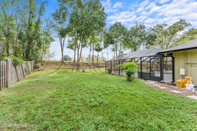 an aerial view of residential houses with outdoor space and trees