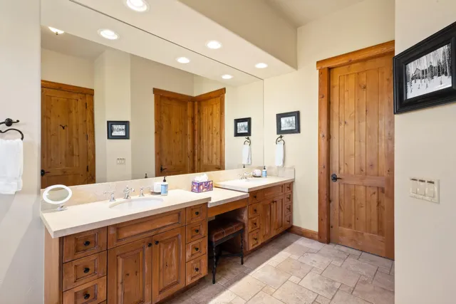 a spacious bathroom with a double vanity sink a large mirror and shower
