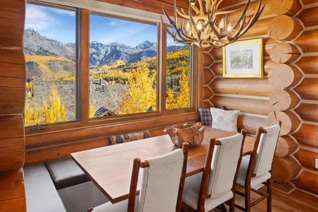 a dining room with a large window and chairs