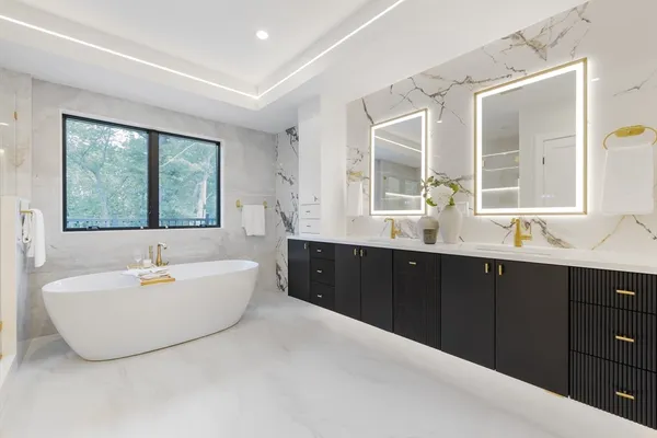 a spacious bathroom with a double vanity sink large mirror and a bathtub