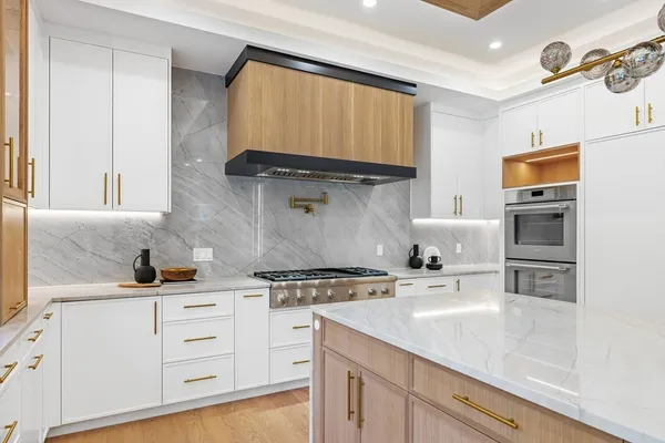 a kitchen with stainless steel appliances a stove a sink and cabinets