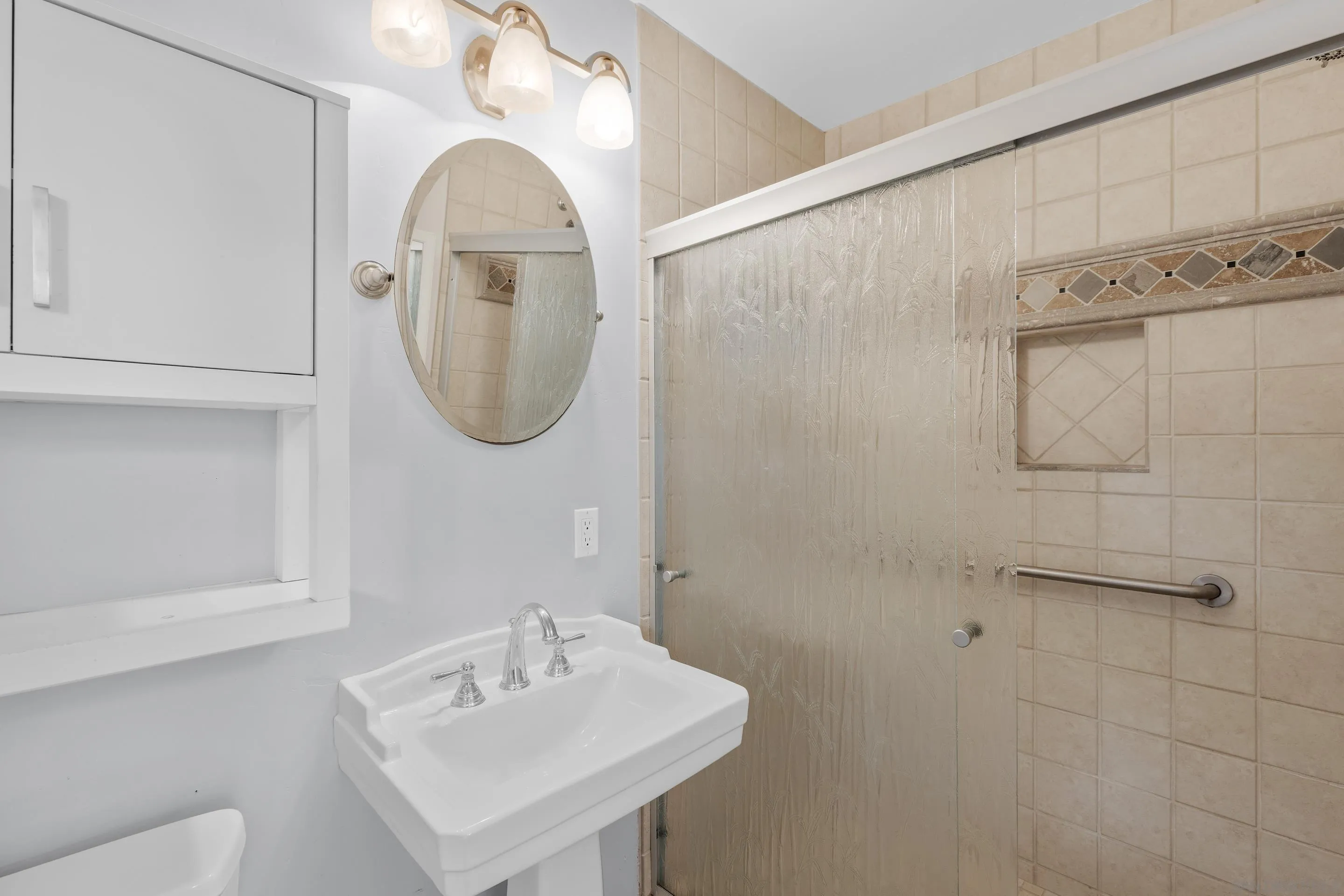 4975 Dawes Street San Diego, CA 92109 - Photo 36 of 39 a bathroom with a sink a mirror and a shower