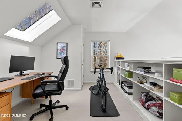 a view of a workspace with furniture and a book shelf