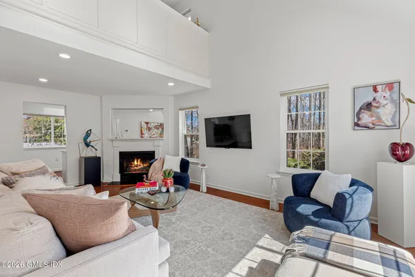 a living room with furniture a flat screen tv and a fireplace