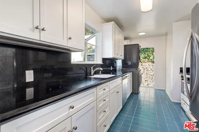 a kitchen with stainless steel appliances granite countertop a sink stove a refrigerator a sink and dishwasher with wooden floor