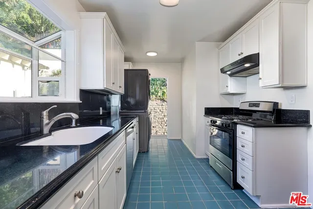 a kitchen with stainless steel appliances granite countertop a stove and a refrigerator