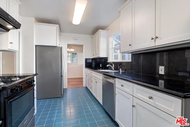 a kitchen with stainless steel appliances a stove a sink and a refrigerator