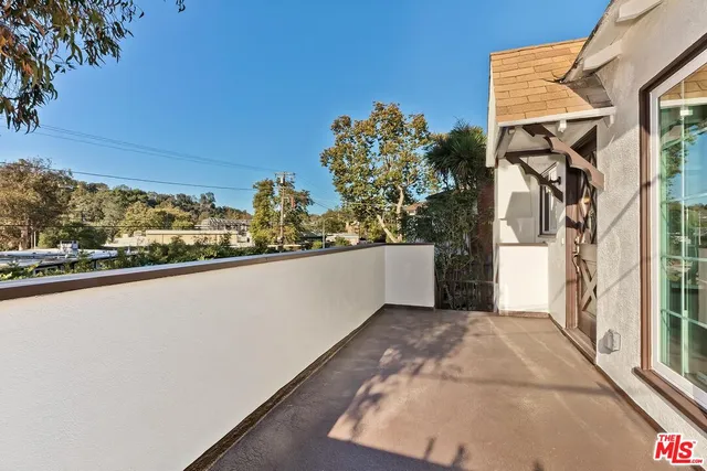 a view of a porch with wooden floor and floor to ceiling window