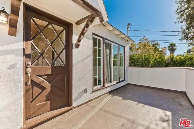 a view of a livingroom with a fireplace a ceiling fan and windows
