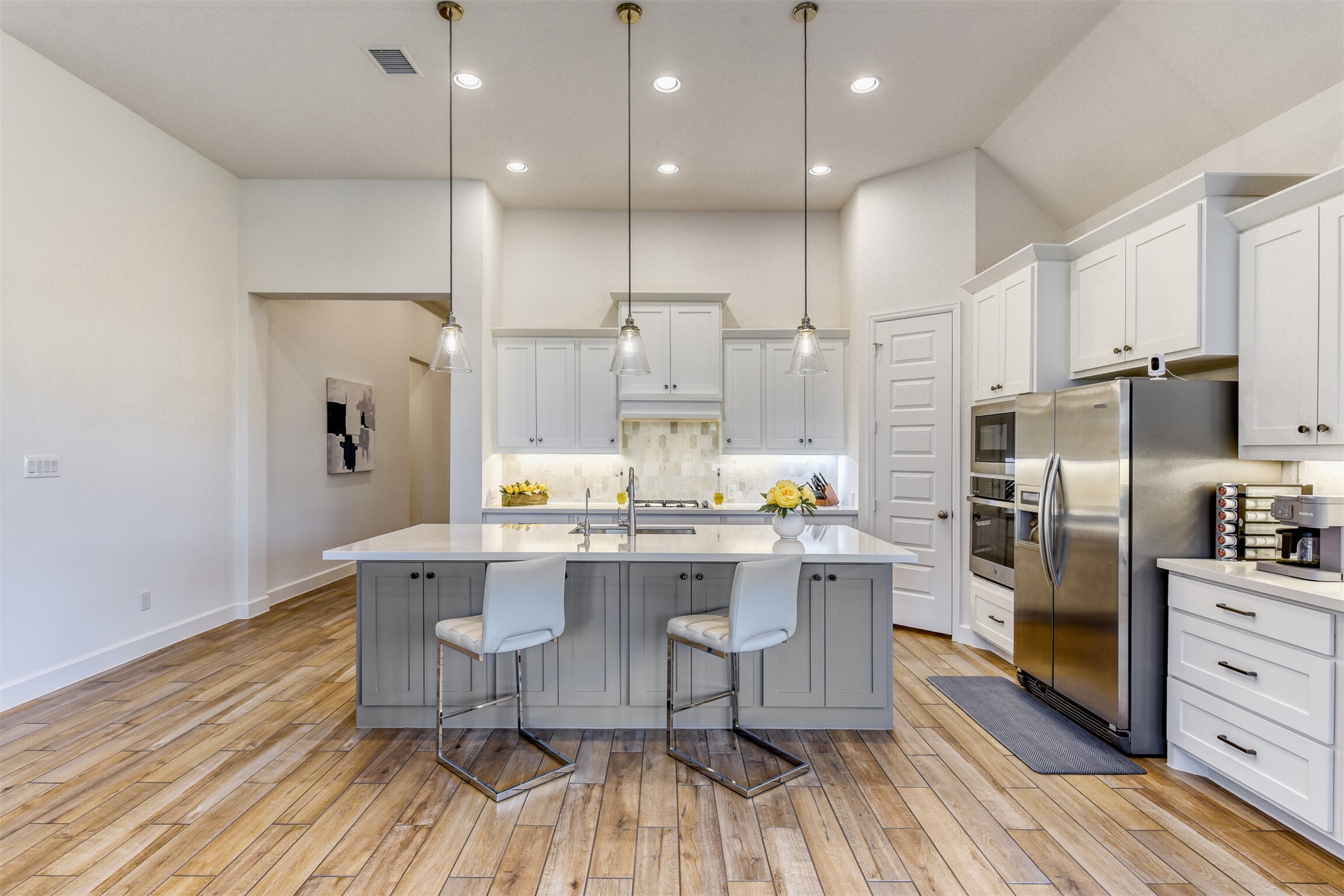 345 Prickly Poppy Loop Kyle, TX 78640 - Photo 13 of 28 Kitchen featuring a breakfast bar area, pendant lighting, a center island with sink, stainless steel appliances, and decorative backsplash