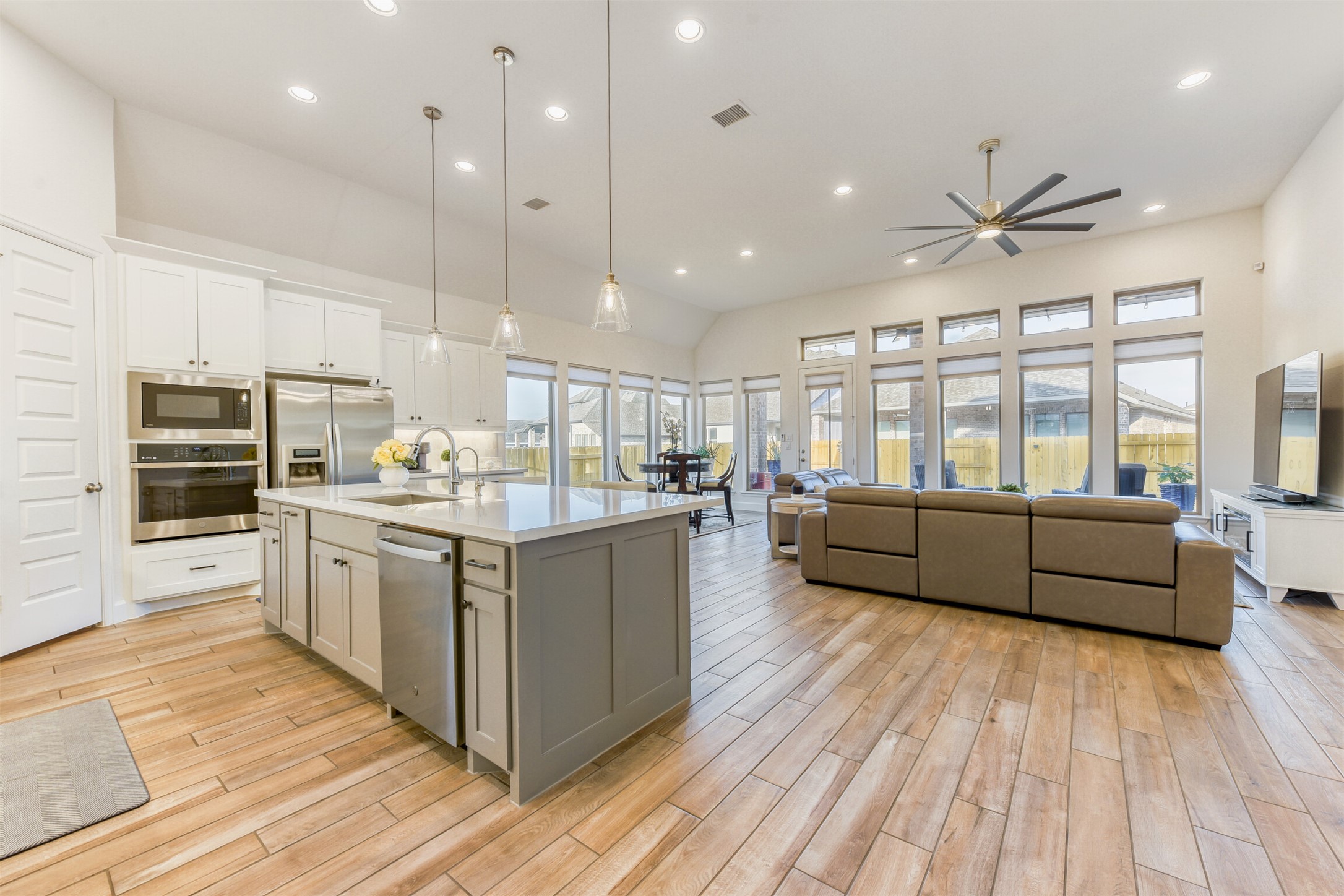 345 Prickly Poppy Loop Kyle, TX 78640 - Photo 28 of 28 Kitchen with hanging light fixtures, stainless steel appliances, open floor plan, a kitchen island with sink, and light wood-type flooring