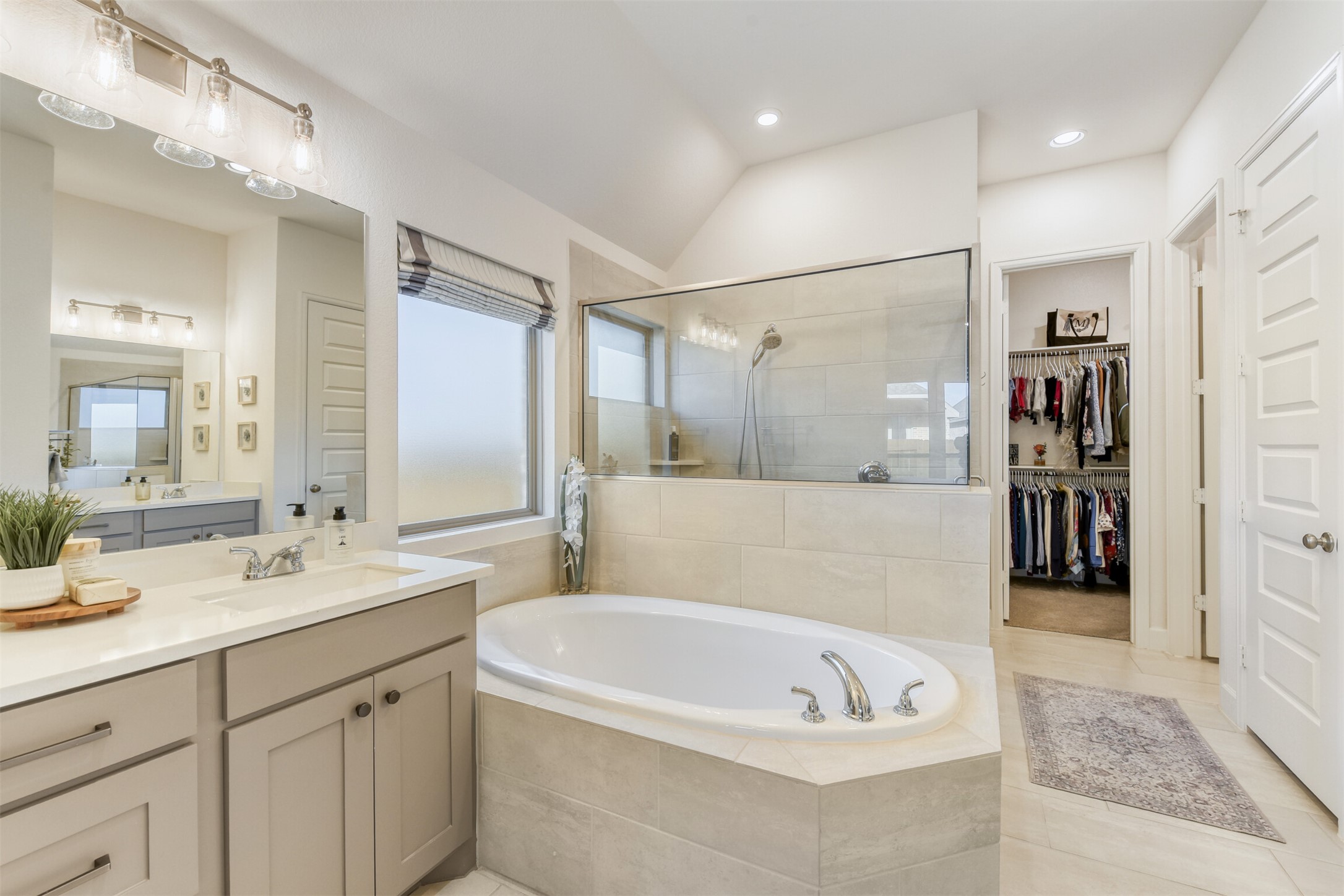 345 Prickly Poppy Loop Kyle, TX 78640 - Photo 15 of 28 Bathroom with a garden tub, vanity, a walk in closet, a stall shower, and light tile patterned flooring