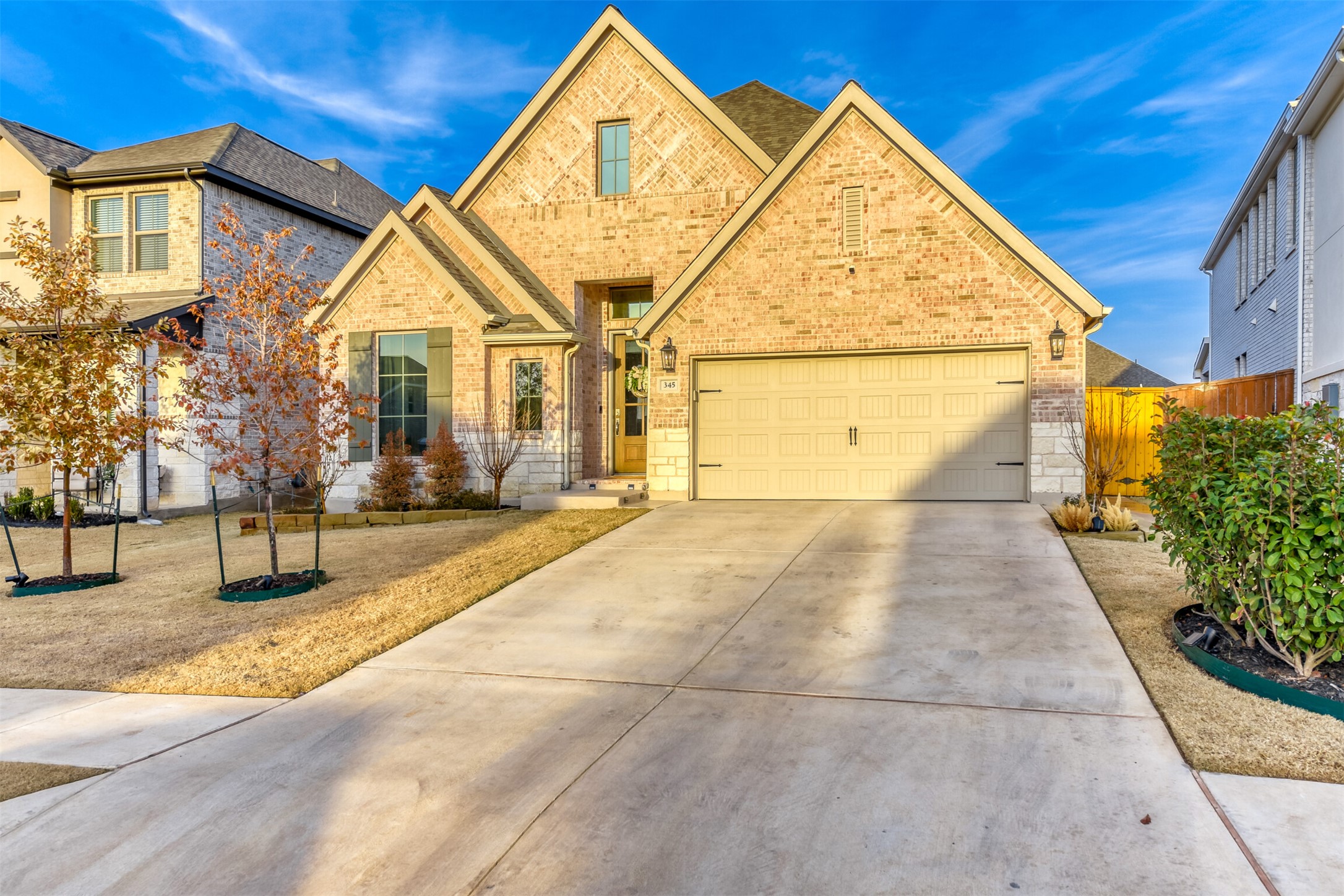 345 Prickly Poppy Loop Kyle, TX 78640 - Photo 2 of 28 View of front of property featuring brick siding, concrete driveway, and an attached garage