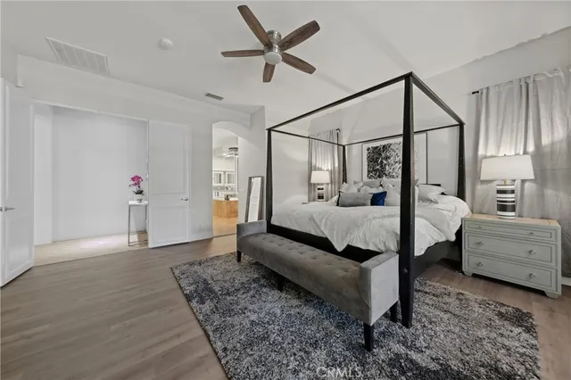 a bedroom with a bed and wooden floor