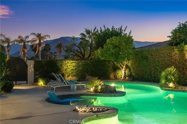 a view of a house with backyard sitting area and swimming pool