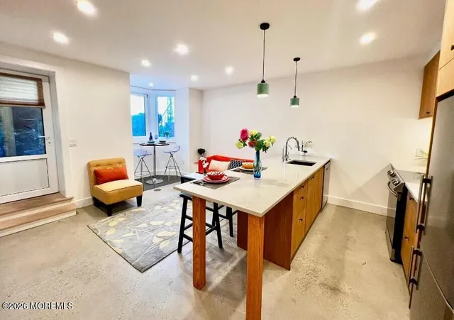 a kitchen with stainless steel appliances kitchen island granite countertop a sink and white cabinets