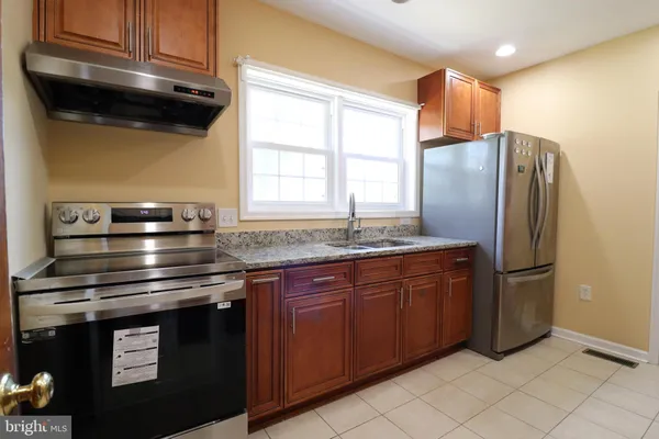a kitchen with stainless steel appliances granite countertop a refrigerator and a stove