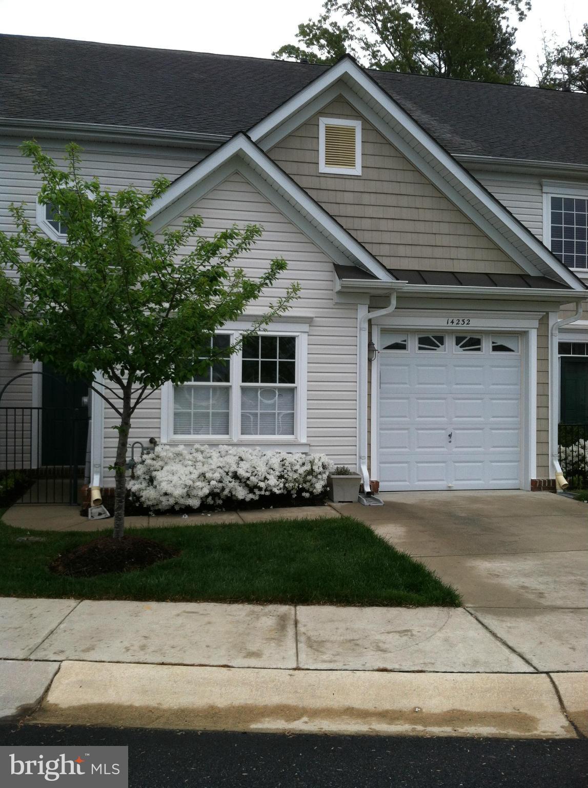 14232 Foxhall Road, Unit 17 Dowell, MD 20629 - Photo 1 of 11 a front view of a house with a yard and garage